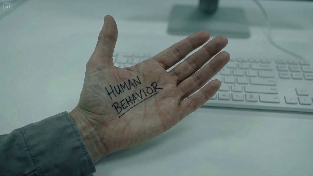 Open palm reading HUMAN BEHAVIOR held over a keyboard at a sterile workstation, cold light.