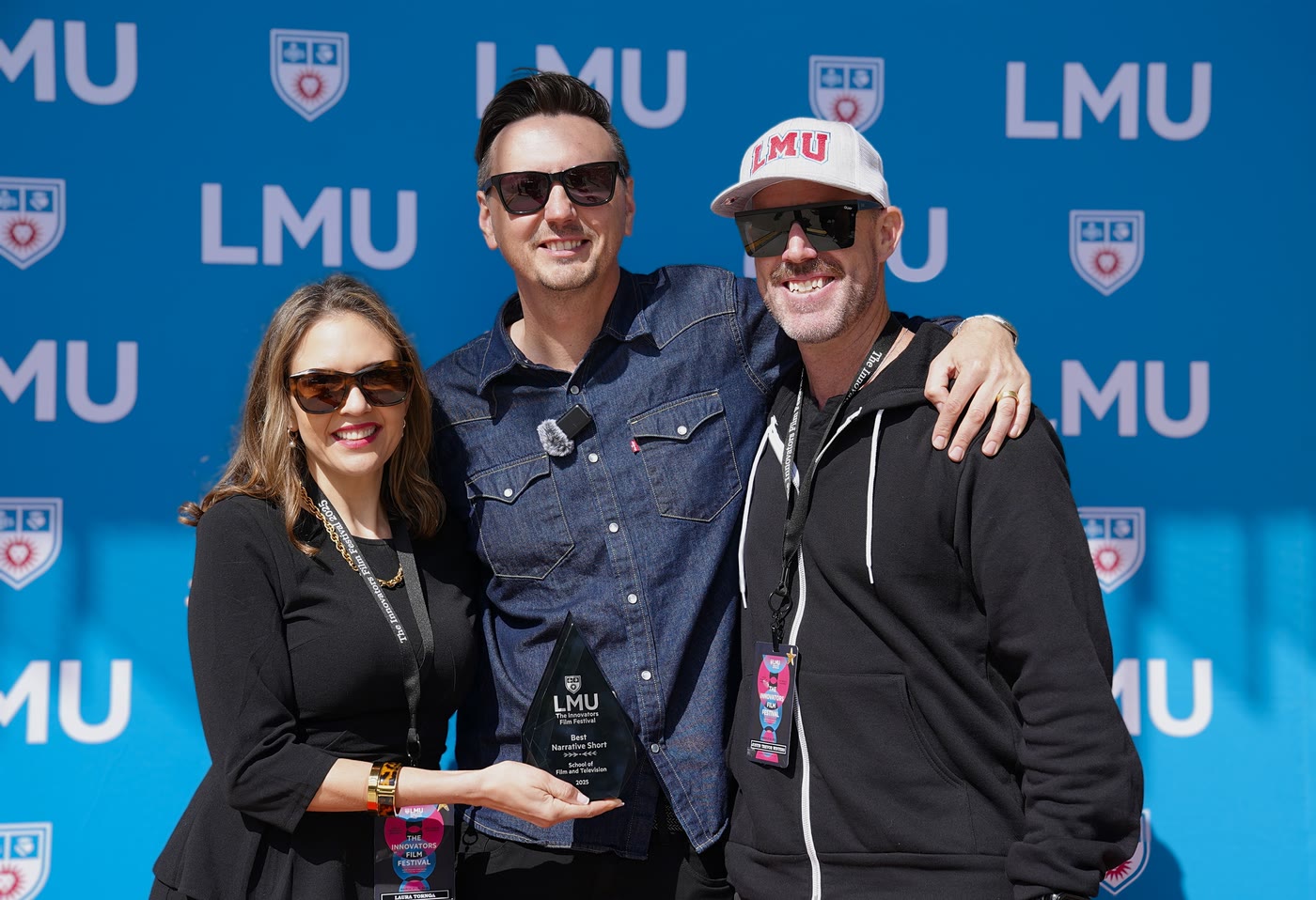 Laura presenting the Best Narrative Short award to winning filmmakers against the LMU step-and-repeat on the festival floor.